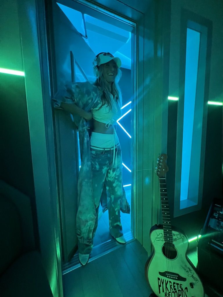 ZÉZÉ in a studio doorway, guitar beside her